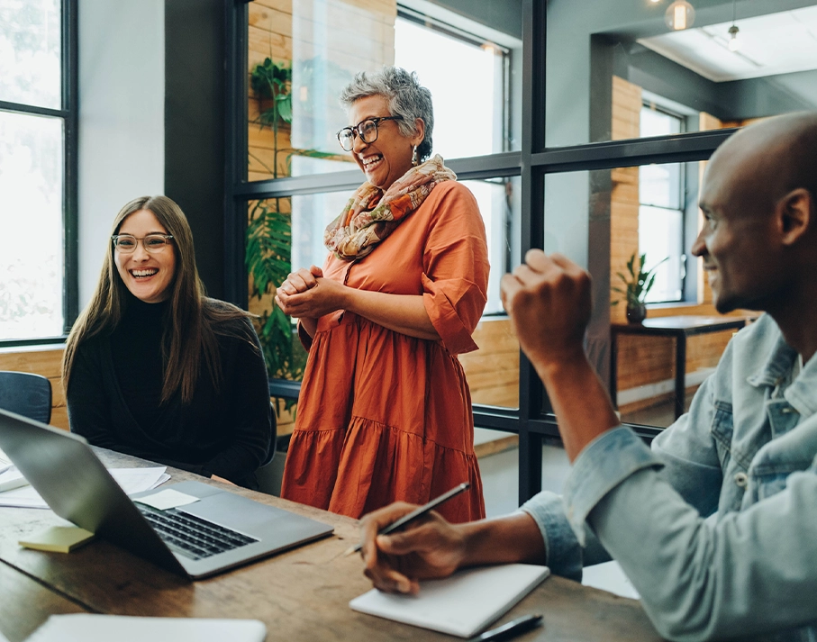 A group of people happily talking in a meeting.