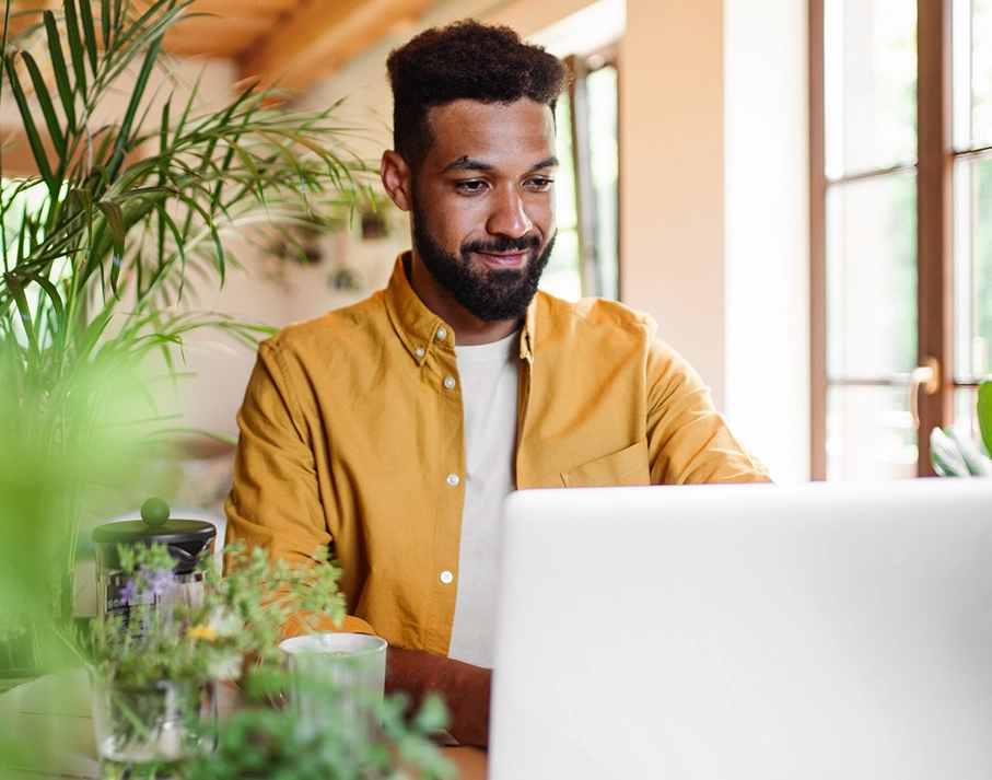 a black male happily working on a laptop