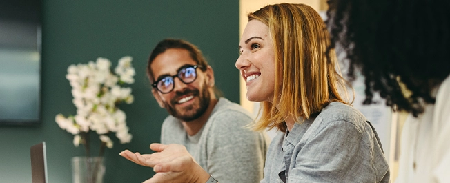 a group of meeting happily talking in a meeting.