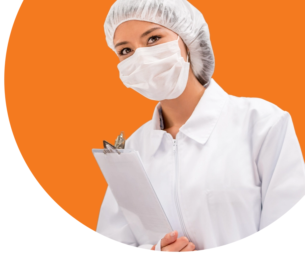 A medical professional wearing a labcoat, a facemask, and hairnet holding clipboard