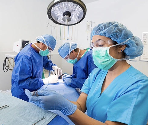 A medical professional wearing scrubs smiles at the camera