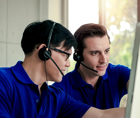 A woman wearing a headset smiles while speaking to a customer