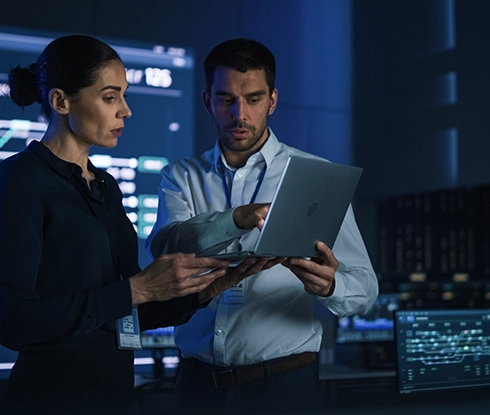 A technology professional looks down at a laptop