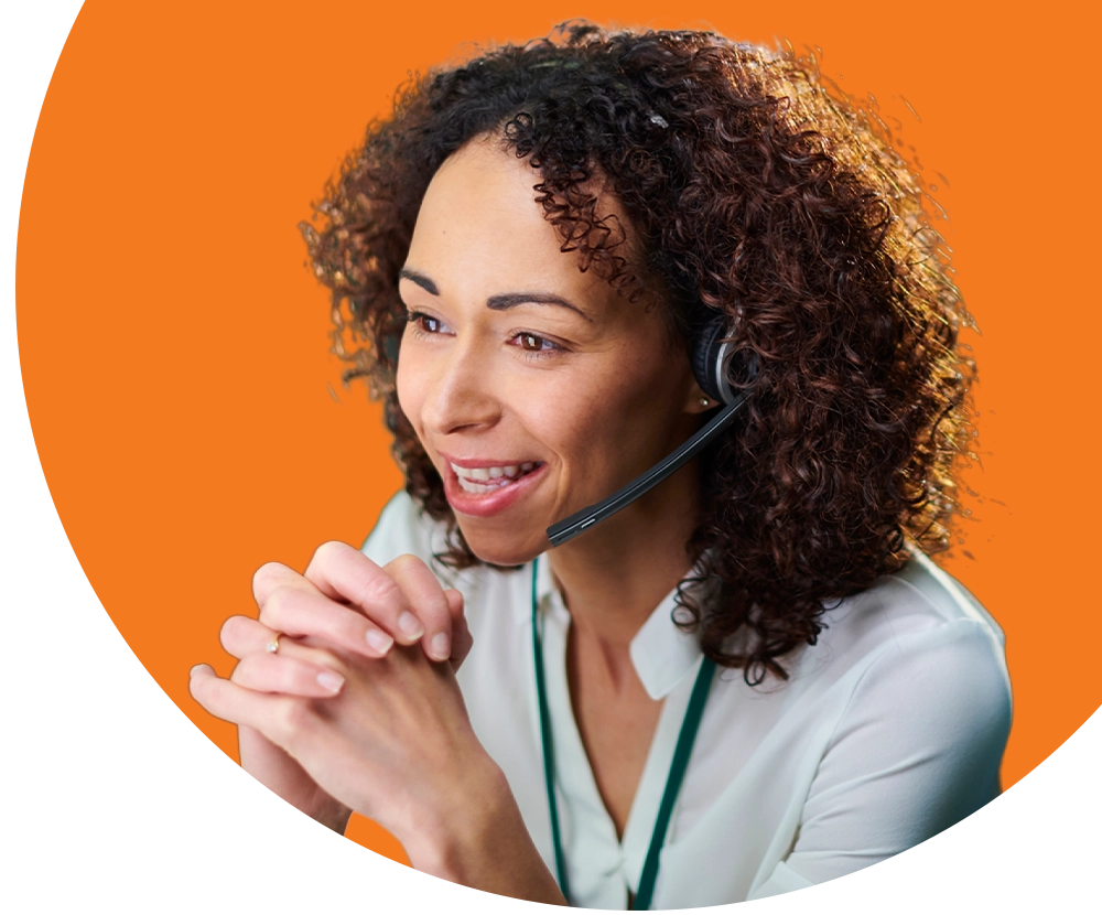 A woman wearing a headset talks to a customer on the phone